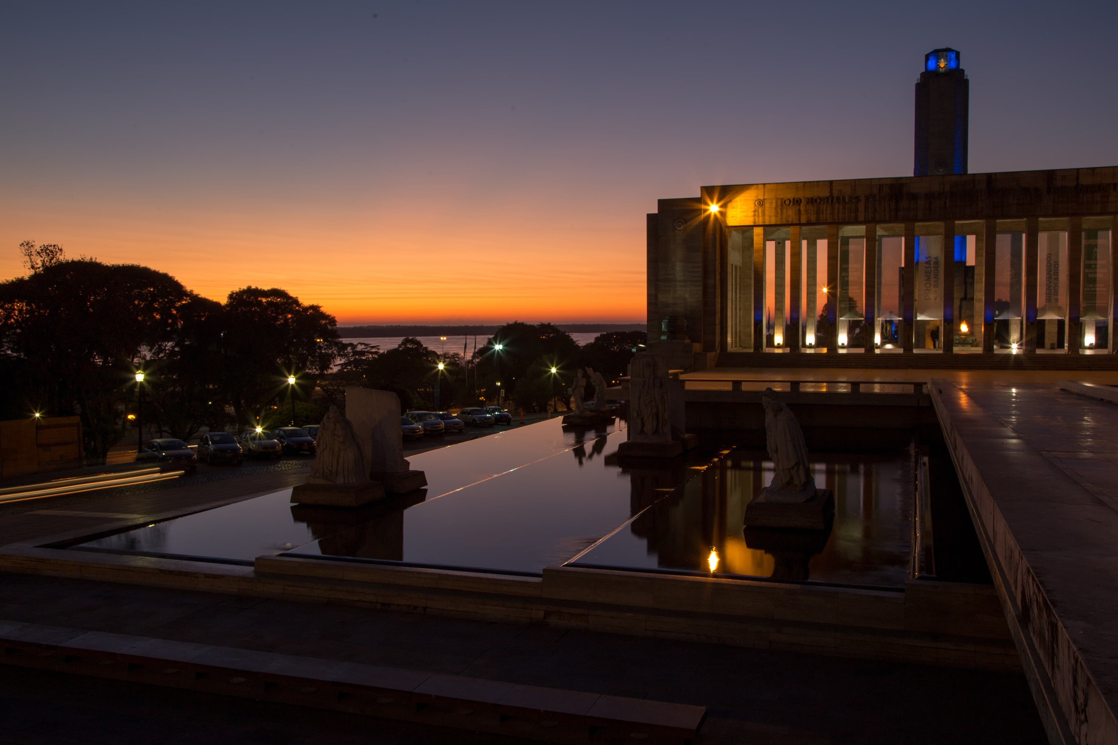 El Monumento a la Bandera al amanecer, con el cielo naranja sobre el río Paraná.